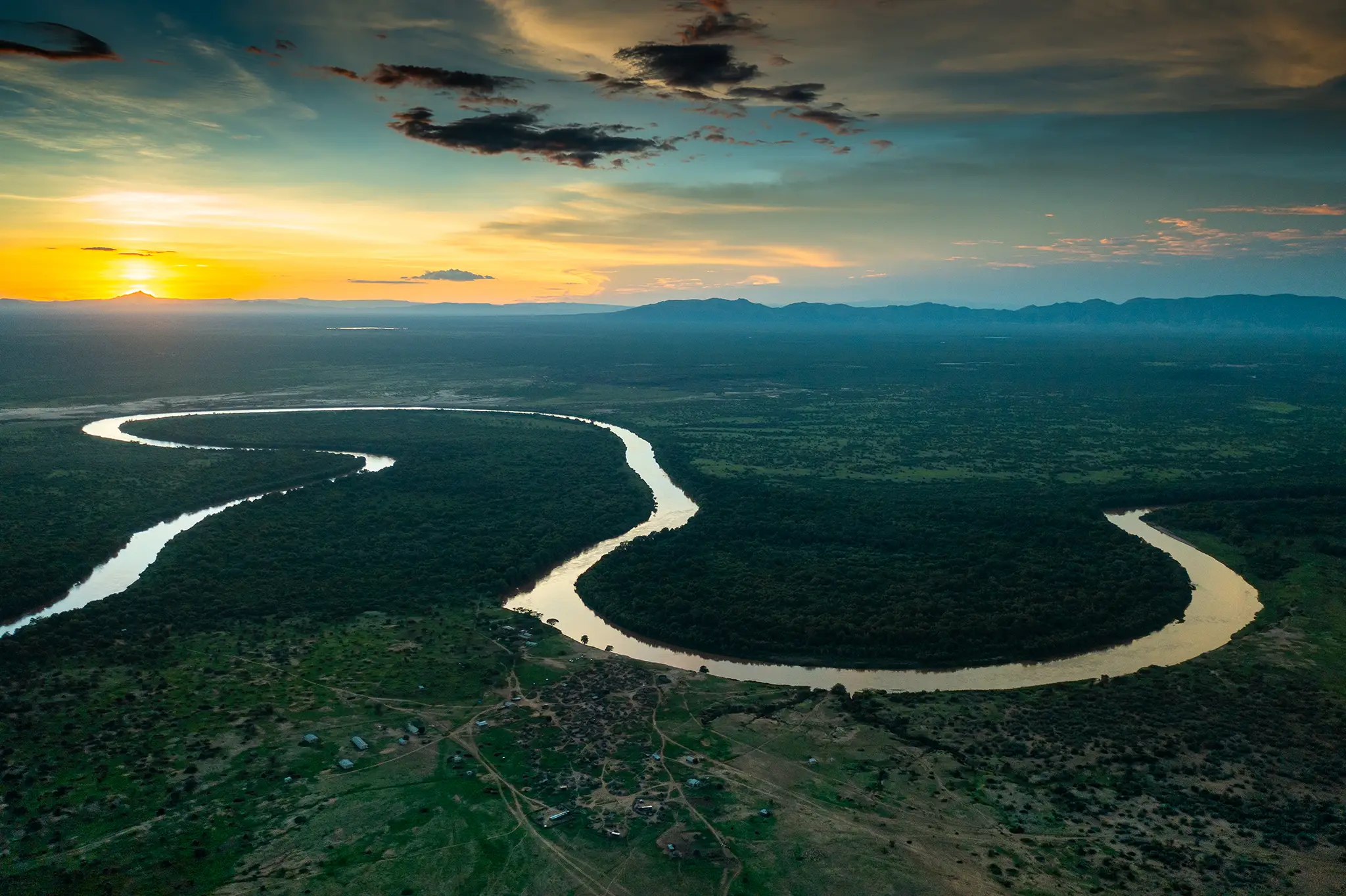 The Omo River winding past a village in the Omo Valley at sunset